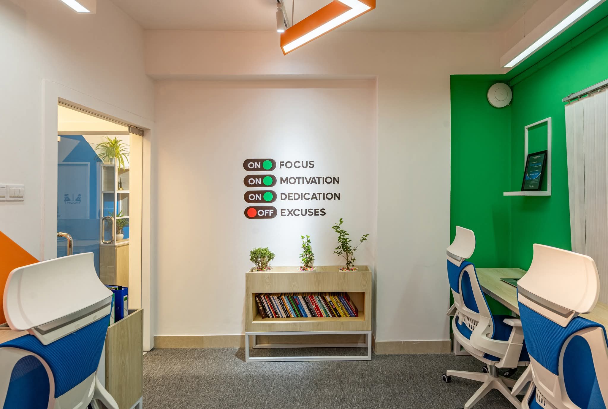 The office's focus and motivation wall, lined with books and plants