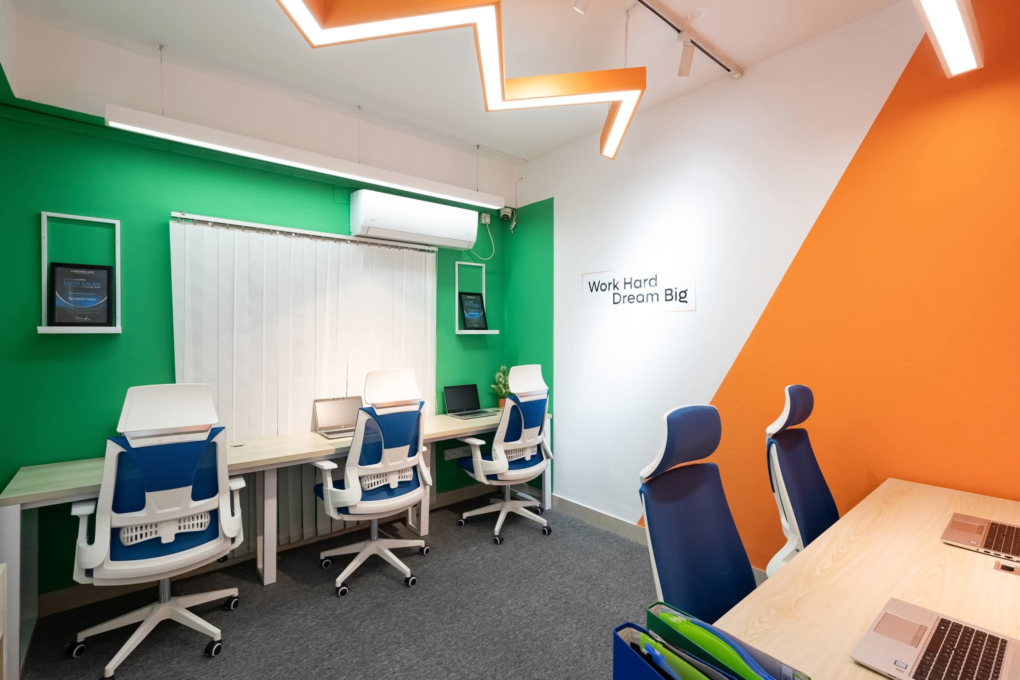 A quiet two-person desk with a view into the lounge