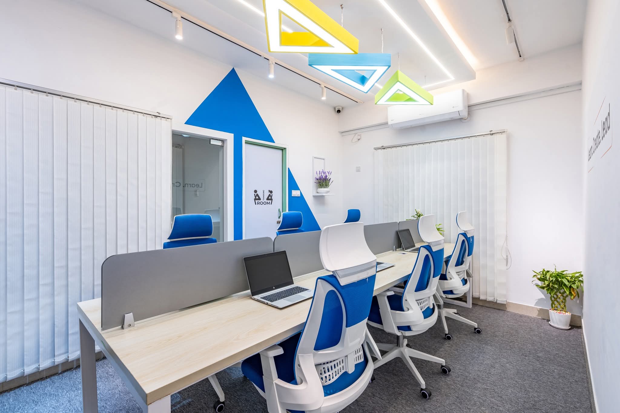 Workstations beneath the 'Together we build something Bigger' wall
